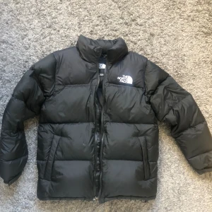 The North Face jacka  - Säljer min north face jacka för säsongen är över. Om man bortser från lappen på högerarmen så är jackan i perfekt skick. Jackan är väldigt varm och har även en luva som man väcklar in i kragen.  Jackan har endast används under en vinter.