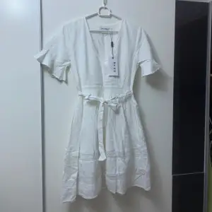 Gullig vit klänning, ny med prislapp. Passar perfekt till studenten eller till en härlig sommardag 🌸kan knytas både fram eller bak. Säljer då den inte kommit till användning.