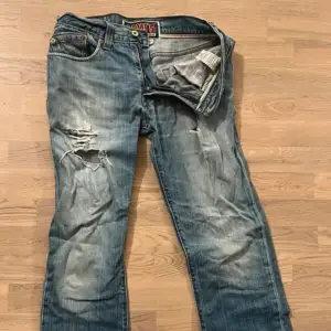 Vintage Levis Jeans i modellen low bootcut. Snygga slitningar och långa. Ascoola fickor med knappar  midjemått 42 cm W30L34 Y2k 