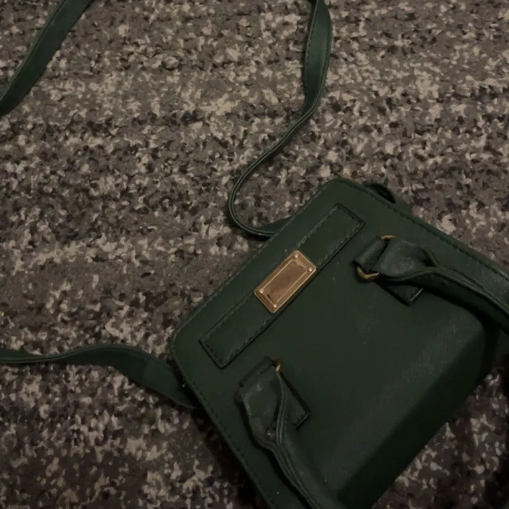 En liten grön väska med både långa och korta band, är jätte fin och inte alls använd. Har guld detaljer på Säljer denna för 75kr plus frakt . Väskor.