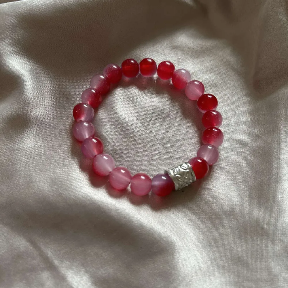 Rött och rosa pärlarmband med en silver berlock💗. Asusteet.