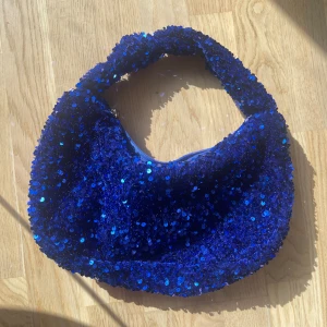 Sequin väska - Blå sequin väska från Nelly. Aldrig anvönd så nyskick, ryms mycket i den! 