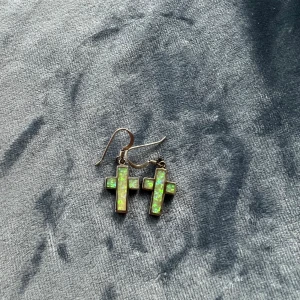 Kors örhängen  - Gröna korsörhängen   Obs! Det kan vara bra att rengöra med alkoholsprit/rengöring innan användning. 