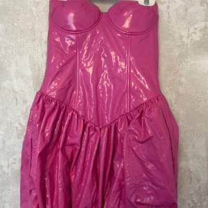 Rosa miniklänning med bandeau i glansigt material. Köpt på NA-KD använd en gång💞