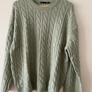 Kabelstickad tröja - Kabelstickad tröja i färgen sage, åt det tunnare hållet