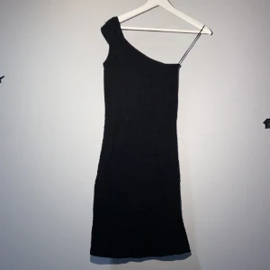 Klänning  - Fest klänning som passar vid alla tillfällen. I väldigt bra skick och bara andvänts två gånger. Den en axlade klänningen formar sig fint efter kroppen och visar kroppens konturer på ett bra sätt. Klänningen slutar åvanför knäna. 330kr original pris
