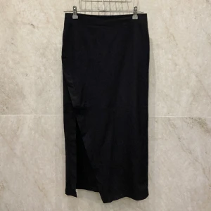 Kjol med slit - Lång skjul med en slit ganska högt upp vid låret 