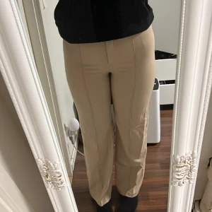 Kosymbyxor - Ett par beigea kosymbyxor från new yorker med pressveck. Sitter Highwaist och har en rak passform. Dom är lite slitna vid innerbenet, se bild 3🙌🏼