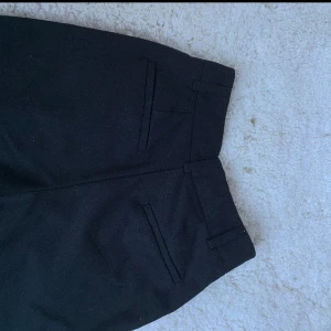 Svarta kostymbyxor - Svarta kostymbyxor från Nakd. Höga i midjan. Använda men i bra skick. 