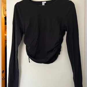 Topp - Svart tröja med dragsko i sidorna från & Other Stories! Passar både till fest och till vardags.  