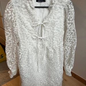 Studentklänning  - Säljer min studentklänning. Superfin med små vita blommor med gulddetaljer och snörning i fram. Använd endast 1 gång så superbra skick🥰 hör av dig om du undrar något!