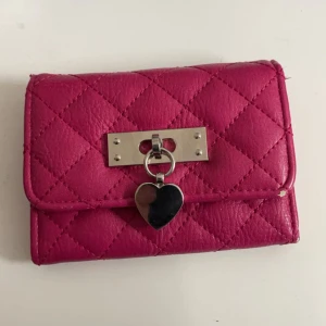Plånbok - En rosa plånbok från DonDonna.  Använd och lite sliten som man ser på sista bilden men fungerar annars skitbra och är inte sönder.