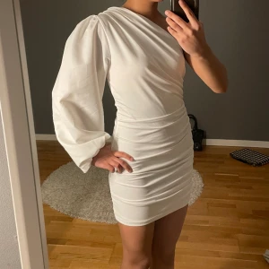 Vit one shoulder klänning - Säljer denna klänning som jag köpte till ett firande men använde den aldrig. Nyskick, skriv vid frågor💗kan användas till studenten, vita teman, firande osv💗