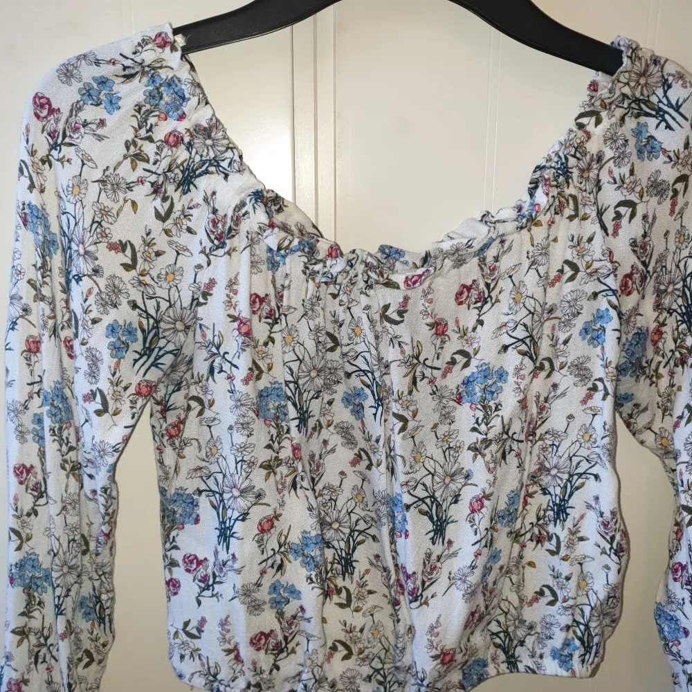 En off shoulder crop top med blommigt motiv. Använd ett par gånger men är fortfarande i väldigt bra skick! Ganska liten i storleken så skulle säga att den sitter mer som en XS.. Toppar.