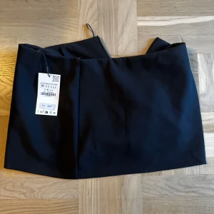Svart kjol - oanvänd - Har inbyggda shorts och har storleken M. Nypris 329kr.  Säljer flera plagg för 50kr. Kolla gärna min profil.