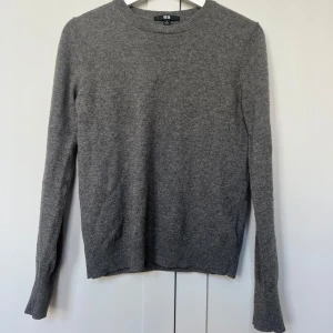 Kashmirtröja  - Mörkgrå stickad tröja i 100% Kashmir från UNIQLO. Använd ett fåtal gånger, ser helt ny ut! Nypris ca 1000kr.🩶