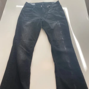 Svarta jeansbyxor - Ett par svarta jeansbyxor i bra skick. Byxorna har en klassisk design med fem fickor och knappgylf. De är raka i modellen och har en normal passform.