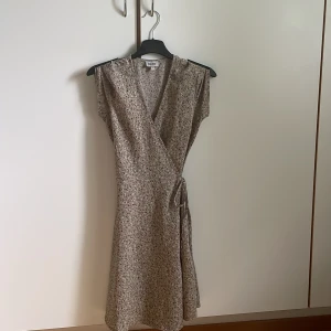 Blommig klänning  - Använd några få gånger och är i bra skick. Den här omolottkläningen är som perfekt till sommaren!