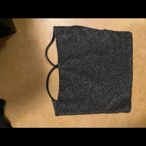 Glittrig topp - Glittrig topp med korsad rygg, bra skick