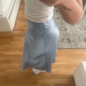 Satin kjol  - Ljusblå satin kjol som går till mitten på vaderna ungefär, aldrig använd💗