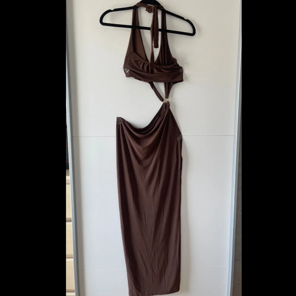 Snyggt formad brun PLT maxi klänning. Jag köpte detta plagg våren 2022 men har endast använt den 1 gång. Jätte bra skick och sitter fint på kroppen.  Obs. Kan tvättas och strykas om önskat🤗. Klänningar.