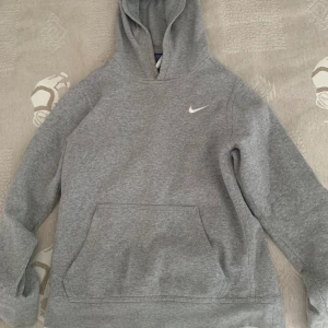 Grå Nike hoodie - Nike hoodie. Hyfsat använd men forfarande i bra skick. Säljer för att den är för liten för mig. Tror att den passar någon som är runt 140-155 cm, då den är från barn sektionen.  Köparen står för frakt 📦 