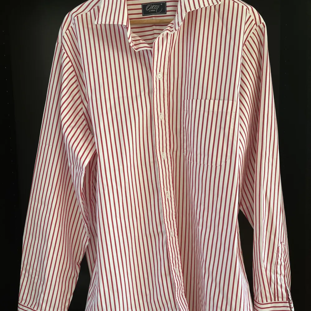 En jättefin skjorta från Oscar i klassiskt vit med röda ränder. Använd endast en gång då den tyvärr inte passade mig. Dyr i inköp.  Storlek 43(CL) med fin passform. . Skjortor.