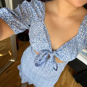 Blommig klänning  - Oanvänd klänning, i gott skick. Perfekt till sommaren. Kom tyvärr aldrig till användning. Har en dragkedja på sidan av klänningen.