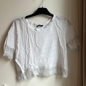 Lace t-shirt från Zara - Fin somrig topp från Zara! Lite genomskinlig och har lace-detaljer PS: Lägger upp för att kolla intresset, är inte 100 på att jag vill sälja🫶