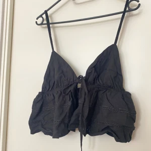 Knytblus - En kort blus som man knyter framtill. Broderie detaljer. Justerbara band. Storlek M. Aldrig använd