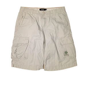 Etnies cargo shorts - Etnies Cargo Shorts i storlek W32. Har två hål vid kanten av fickorna. Jag på bilden är 180 cm. Mått: midjemått - 58 cm, längd - 44 cm, benöppning - 31 cm. Skriv för fler bilder och frågor!