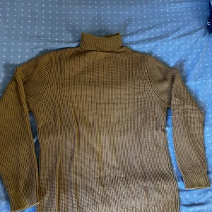 Stickad Tröja - Tjock, brun, stickad tröja köpt från New Yorker. Använd i bra skick. Hög hals