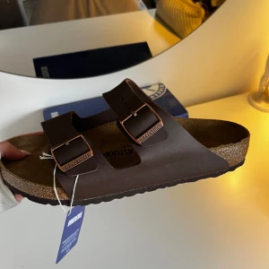 Birkenstock Arizona strl 45 - Säljer dessa oanvända birkenstock i storlek 45. Säljer på grund av att jag inte kan lämna tillbaka (beställde fel storlek). Legat i orginalförpackningen och har alla lappar på, sprillans nya! Priset kan diskuteras! Nypris 1195:- 