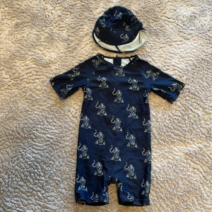 Uv dräkt  - Marinblå uv dräkt med solhatt från mini  a ture med tigrar. 