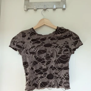 Cool magtröja - Magtröja med ett unikt hålmönster. Knappt 40 cm lång mätt från den högsta punkten av axeln och ned.