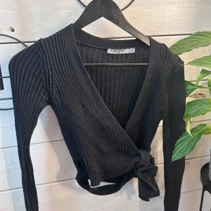 Knyttröja  - Passar XS, lite tajt om man bär S. Använd några gånger. Man knyter ihop banden på ena sidan.