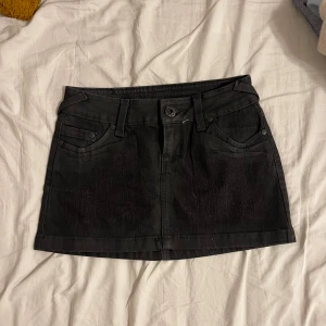 Mini jeanskjol  - Säljer en super snygg svart mini jeans kjol från mango. Mycket detaljer plus lågmidjad 😇✌️