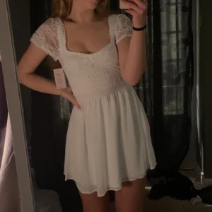 Studentklänning - Jättefin vit klänning från nelly som är slutsåld online, perfekt till studenten eller sommaren!! Storlek 38. Nyskick (aldrig använd, lappen kvar).