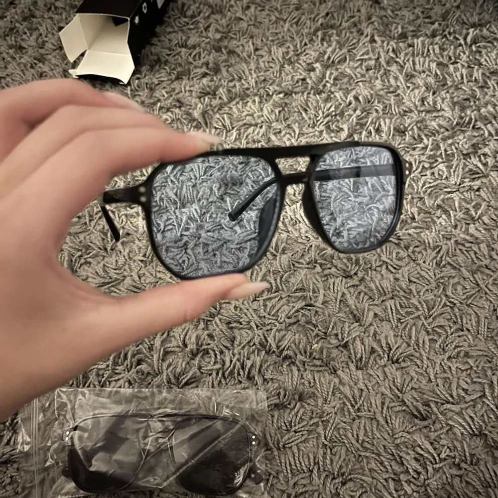 Solglasögon från Ensaroje med blått glas, helt oanvända och förpackning samt tvätt till glaset medföljer.. Accessoarer.
