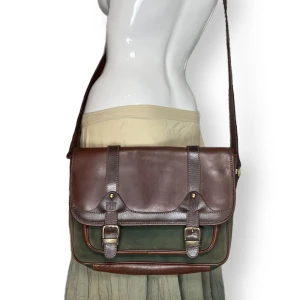 Väska  - Fin skolväska, från Exit. Några repor syns på tredje bilden. Brunt skinn på baksidan. Kan skicka flera bilder vid intresse! Går inte att spänna väskans band mindre än vad som syns på bilden. 35cm bredd, 25cm i höjd & 10cm i djup 