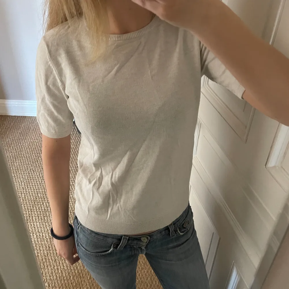 Säljer denna fina stickade T-shirten💕jag skulle säga att färgen är lite ljusgrå/beige typ!. Toppar.