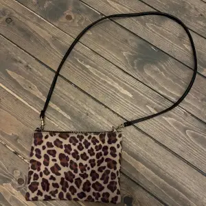 Handväska från hm, leopard på ena sidan och svart på andra sidan med läderband