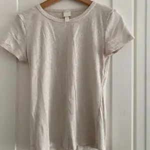 Fin t-shirt från H&M. Fin nyans av vit, lite melerad.  Använd ett fåtal gånger så mycket fint skick.