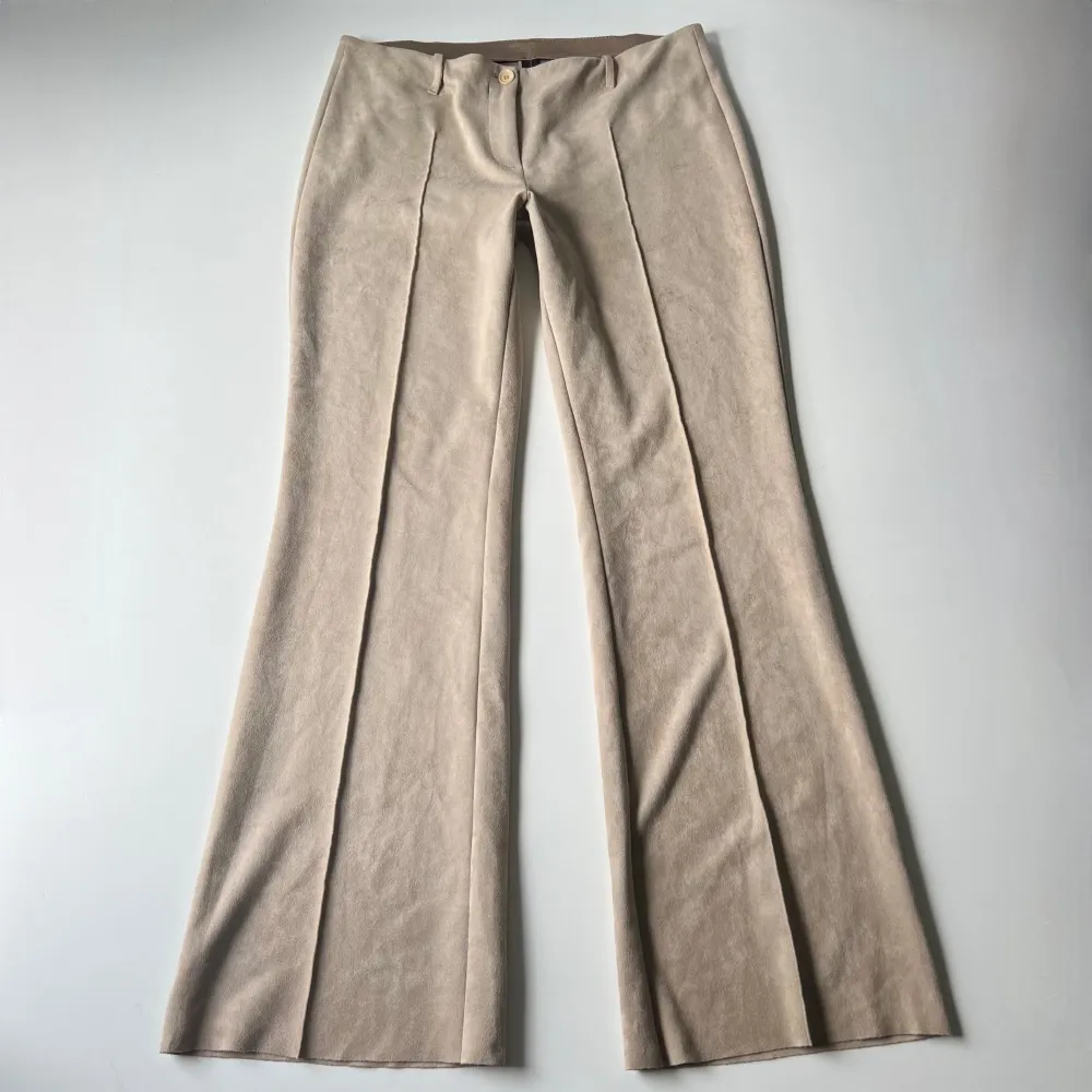 Vintage lågmidjade beige bootcut byxor från Marccain i suede / mocka liknande  material. Midjemått: 84-90 cm då det är elastiskt band. Innerbenslängd: 80 cm. Jag är 176 cm 💕. Jeans & Byxor.