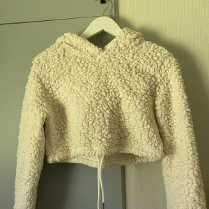 Fluffig hoodie - Croppad supermysig hoodie. Köpt på shein. Storlek S och knappt använd. Har snören man kan dra åt runt midjan. Super varm och mysig.