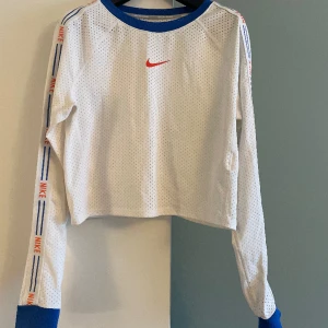 Nike topp - Nike tröja i funktionsmaterial i storlek S. Lång ärmar, något kortare i midjan. Sparsamt använd(ca 3-6ggr). Kan användas både som träningströja eller vardagstop. 