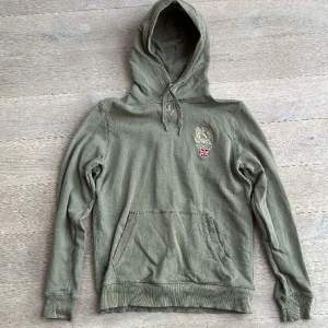 Olivgrön Morris hoodie - Skick: mycket bra  Material: Bomull Storlek: M (Killen på bilden är 1.85 m) Vid funderingar är det bara att skriva.