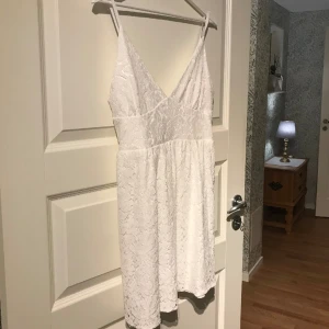 Vit spetsklänning  - Vit spetsklänning från Nelly i storlek 38/S. Använt en gång som studentklänning. I perfekt skick
