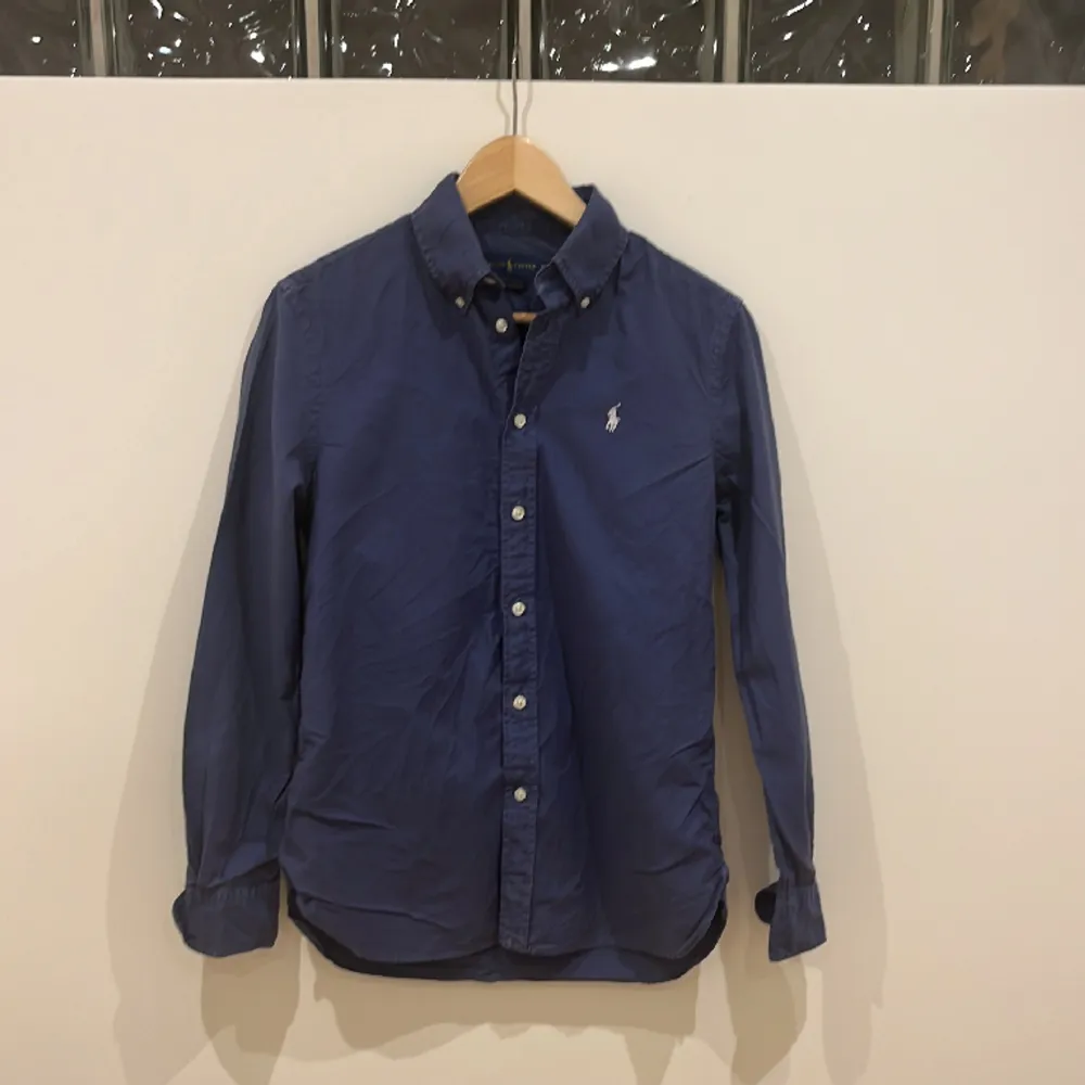 Vanlig marin blå ralph lauren skjorta i storlek XS med en relaxed fit, säljer då den inte blir använd. Den är i bra skick.. Skjortor.