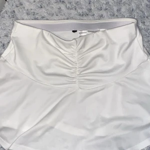 Söt kjol S - Säljer denna jättesöta vita låg midjade kjol från hm. Liknar en tennis/paddel kjol. 